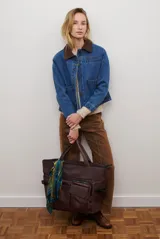 Chaqueta de jean azul con cuello de gamuza color camel, bolsillos delanteros y cierre de botones.