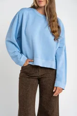 Buzo lila oversize confeccionado en 100% algodón, con cuello redondo, mangas largas y puños y dobladillo acanalados. Presenta un pequeño detalle bordado en el bajo.