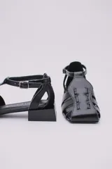 Sandalias de cuero estilo jaula en color rojo, con punta cuadrada, taco cuadrado bajo en color negro y cierre con hebilla ajustable en el tobillo.