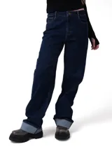 Jeans de corte relajado y tiro medio en color azul índigo. Presenta diseño clásico de cinco bolsillos, cierre de cremallera con botón y puños enrollados en la parte inferior de las piernas.