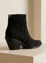 Bota corta de cuero vacuno en color azul oscuro, con diseño de caña media, punta almendrada y taco cuadrado de 7 cm. Presenta costuras decorativas laterales y suela de caucho antideslizante.