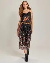 Top de tirantes finos con escote en V, confeccionado en viscosa con estampado temático western que incluye motivos de vaqueros, cactus y herraduras sobre fondo negro.