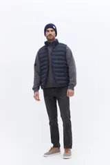 Chaleco puffer de nylon con diseño acolchado horizontal, cuello alto y cierre frontal. Presenta un corte recto y liviano, ideal para superposición de capas.