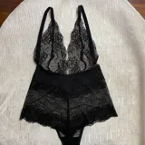 Body de encaje negro con escote pronunciado en V, breteles regulables y diseño entallado.