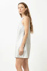 Vestido corto plateado de lino con acabado metalizado, corte recto y cuello cuadrado.
