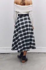 Falda midi de corte acampanado con estampado de cuadros escoceses en tonos blanco y negro. Presenta un diseño de cintura alta con detalle de solapa y cierre lateral.