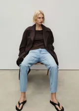 Jeans de tiro alto con diseño mom-fit, de cinco bolsillos y cierre frontal con cremallera y botón, en tejido de algodón estilo tejano vaquero de color celeste lavado.