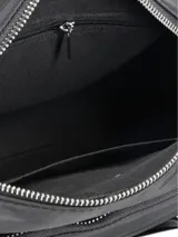 Bandolera de nylon color negro, con múltiples bolsillos con cierre, herrajes plateados y correa ajustable estampada en blanco y negro.