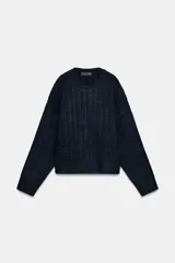 Jersey de punto de cuello redondo y manga larga, con diseño de ochos verticales en toda la prenda. Presenta un acabado de tacto suave y corte clásico.