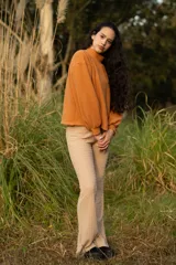 Buzo color naranja con cuello alto y mangas abullonadas.