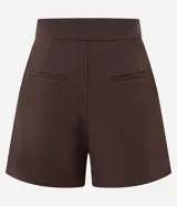 Short de sastrería color marrón, de cintura alta con cierre tradicional. Presenta recortes delanteros con costura aparente, bolsillos laterales con tachuelas metalizadas y bolsillos traseros decorativos.