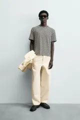 Camiseta de manga corta con cuello redondo y calce relajado, confeccionada en tejido de rayas horizontales blancas y negras.