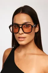 Lentes de sol con armazón de policarbonato negro y cristales tintados en tono ámbar, con diseño de estilo retro y protección UV400.