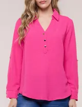 Blusa verde de calce holgado y caída fluida, confeccionada en tejido tipo crepé. Cuenta con cuello camisero con solapa, escote en V y cierre parcial al frente con tres botones metálicos. Las mangas son largas con puños abotonados.
