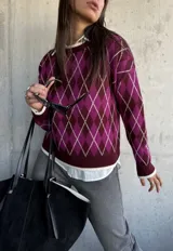 Sweater de tejido de punto con diseño de rombos en tonos bordó y magenta, con cuello redondo y terminaciones en color crema.