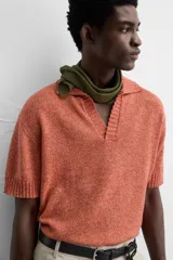 Polo de punto de corte relajado, confeccionado en mezcla de algodón. Presenta cuello solapa con abertura frontal, manga corta y acabados en rib en puños y bajo.