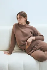 Pantalón de descanso de tejido suave y texturizado, color blanco, con cintura elástica ajustable mediante cordón y puños acanalados en los tobillos.