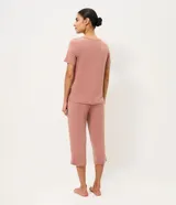 Pijama largo de dos piezas confeccionado en viscolycra color rosado. Incluye una remera de manga corta con escote en V adornado con encaje y un pantalón de corte recto con cintura elástica.