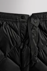 Pantalón de esquí acolchado con diseño de rombos, color negro. Presenta cintura elástica con cierre de botón a presión, bolsillos laterales con cremallera y bajos ajustables con cordón elástico.