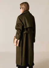 Abrigo tipo trench de diseño oversize y corte recto, color verde militar. Presenta cuello de solapa ancha, cierre frontal de doble botonadura, cinturón desmontable con hebilla y bolsillos laterales. Incluye trabillas en los puños y forro interior.