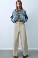 Pantalón de tiro medio con diseño de pierna ancha y pinzas frontales. Cuenta con bolsillos laterales ocultos, falsos bolsillos traseros de vivo, trabillas en la cintura y cierre frontal con cremallera y ganchos metálicos.