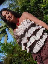 Top strapless color crema con volados estructurados en la parte delantera y elástico en la espalda.