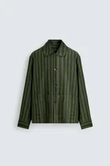 Sobrecamisa de hombre con cuello solapa, manga larga y cierre frontal de botonadura. Presenta un estampado de rayas verticales en tonos de verde oliva y verde oscuro. Incluye bolsillos plastrón en la cadera.