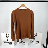 Buzo de punto color marrón terracota, con cuello redondo y manga larga.