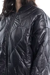 Campera bomber negra de tela satinada con bordado rojo en el pecho. Es reversible.