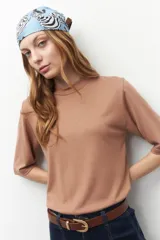 Remera de tejido de punto color camel, de manga corta y cuello alto.