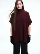 Chaleco tipo poncho de tejido de punto en color bordó, con cuello polera y diseño amplio con laterales abiertos.
