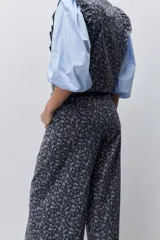 Pantalón de tiro alto con silueta amplia y piernas rectas, confeccionado en algodón con estampado floral. Cuenta con cierre frontal de botón y cremallera, y bolsillos laterales funcionales.