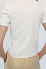 Camiseta de algodón con corte regular, escote redondo amplio y manga corta. Presenta un diseño básico con bajo recto.
