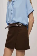 Short cruzado de tiro medio con diseño frontal tipo falda, color negro, de líneas simples y calce cómodo.