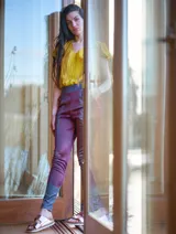 Pantalón de satén pintado a mano con diseño abstracto en tonos verde azulado y ocre.