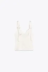 Top de satén rosado con escote en pico y tirantes finos que se atan con lazos.