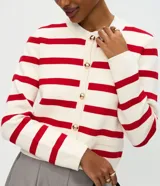 Cardigan de punto con diseño rayado horizontal en color blanco y rojo. Presenta escote redondo, manga larga, cierre frontal con botones dorados y bolsillos delanteros discretos. Posee una caída estructurada y acabado sofisticado.