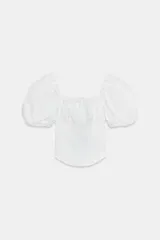 Top blanco de escote cuadrado con fruncidos en el pecho y mangas cortas abullonadas tipo globo. Cuerpo de tejido acanalado ajustado.
