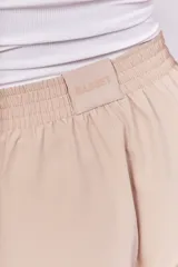 Pantalón recto color beige con cintura elástica y cierre metálico.