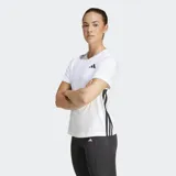 Remera deportiva Adidas de entrenamiento, color blanco con las icónicas tres rayas negras en los laterales y logo de la marca en el pecho. Presenta cuello redondo, mangas cortas y un diseño ergonómico que favorece la libertad de movimiento.