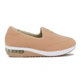 Zapato casual tipo slip-on de lycra color negro, con suela de plataforma blanca y cámara de aire en el talón. Presenta un aplique circular metálico con logo en el empeine.