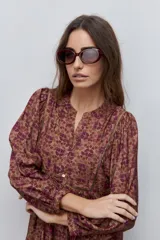 Vestido largo de silueta amplia y caída fluida, con estampado y recortes fruncidos que aportan movimiento. Presenta escote con abertura, cierre frontal con botones y mangas largas de volumen amplio con puños elastizados.