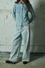 Jean de corte wide leg con tiro alto y diseño de cinco bolsillos. Presenta un acabado lavado ácido en tono gris claro.