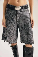 Bermuda de denim color gris con efecto acid wash y acabado brillante, de calce amplio y oversized. Cuenta con diseño largo hasta la rodilla, roturas y ruedo deshilachado.