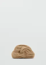 Bolso tipo clutch de fibra natural trenzada en color beige, con diseño frontal fruncido y nudo central, y cierre superior de aro a presión.