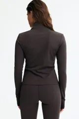 Campera deportiva de manga larga con cierre frontal completo y cuello alto, color marrón oscuro, confeccionada en tejido elástico con tecnología SoftMove y DryMove. Cuenta con mangas largas con aberturas para los pulgares en los puños.