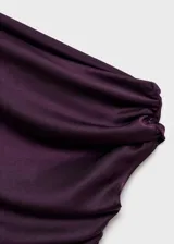 Vestido midi de satén color violeta oscuro, con diseño drapeado en el escote y un hombro al descubierto, de manga corta caída y bajo asimétrico.