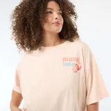 Remera oversize de manga corta color salmón con estampado frontal que incluye texto y gráfico de naranjas.
