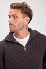 Sweater verde oscuro de punto con cuello alto y cierre de cremallera parcial. Tejido de canalé vertical.