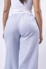 Pantalon de corte amplio y tiro bajo, confeccionado en tela de franela con estampado de cuadros en tonos blanco, negro y gris. Cuenta con cintura elástica con cordón ajustable y bolsillos laterales.